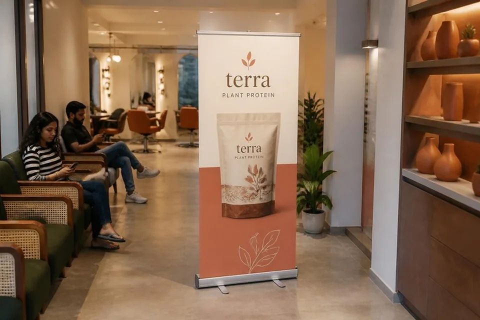 Unlit printed plant-protein standee beside a salon waiting area
